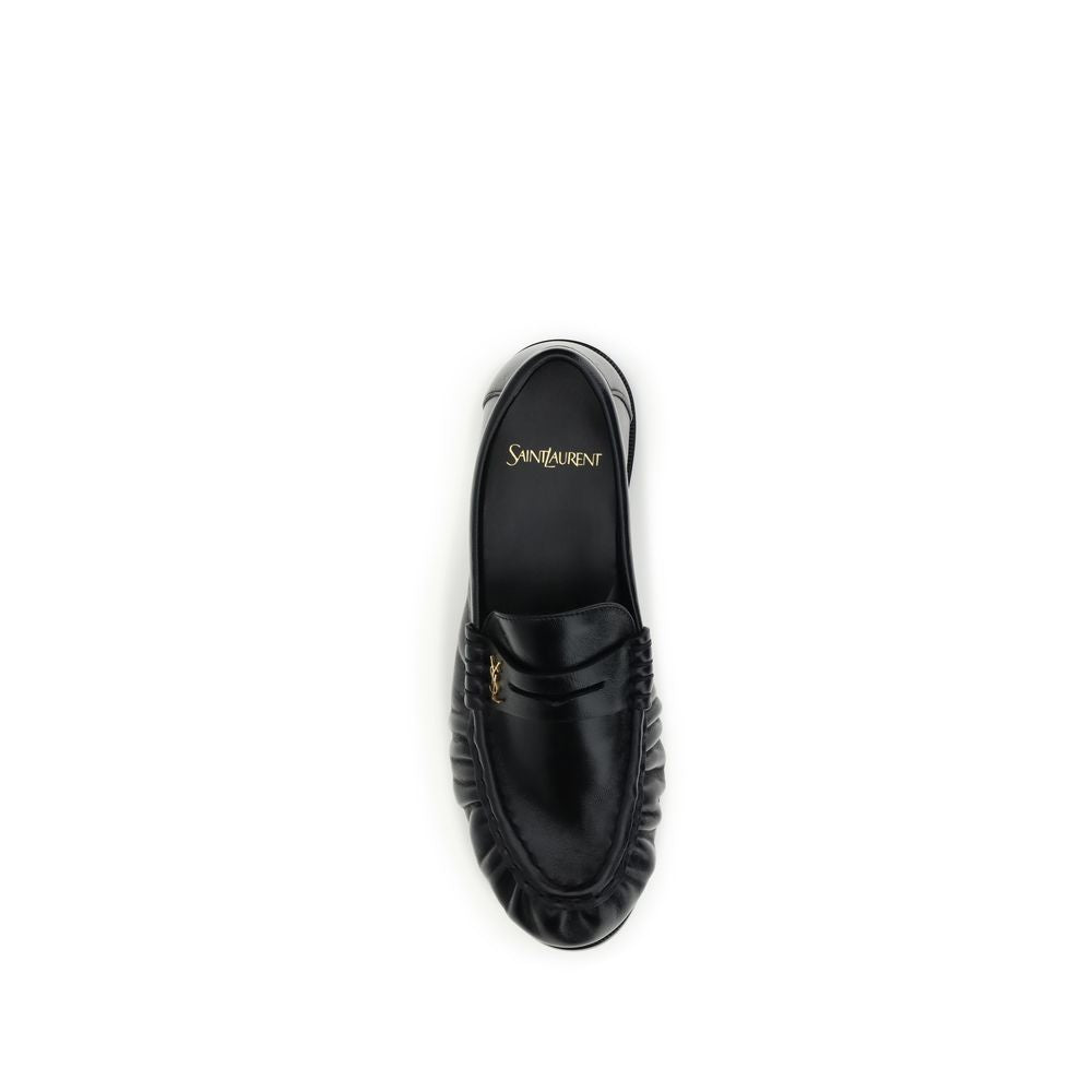 This Flat Loafer Slip-On Shoes by Saint Laurent for women in leather & metal black, gold & signature features an exquisite silhouette from the Cassandre Women's Leather & Metal Flat Loafer Slip-On Shoes collection, defined by a sophisticated flat and elegant moc toe style.