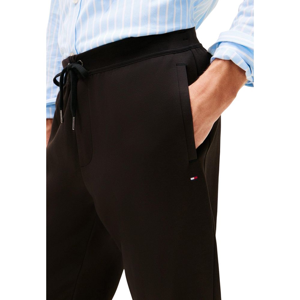 Activewear Jogger Pants by Tommy Hilfiger for men in cotton polyester black features a contemporary silhouette with , a contemporary regular-fit, long hem, and for a premium, high-performance aesthetic.
