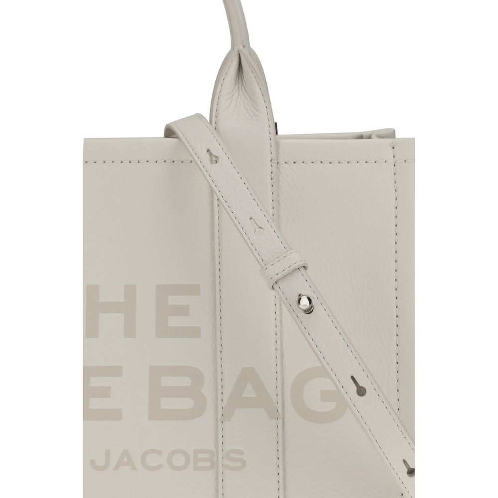 This Medium Tote Handbag by Marc Jacobs for women in bos taurus calf grained leather and white, patterned & monogram presents a sculptural silhouette featuring a secure zipper, ample , and versatile shoulder-strap, handle & adjustable-strap for a sculptural finish.