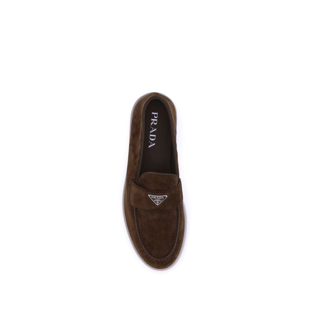 Flat Loafer Slip-On Shoes by Prada for men in bos taurus calf suede leather brown showcases a impeccable silhouette as Men's Bos Taurus Calf Suede Leather Flat Loafer Slip-On Shoes, artfully designed with a impeccable flat and refined almond toe style for a impeccable finish.