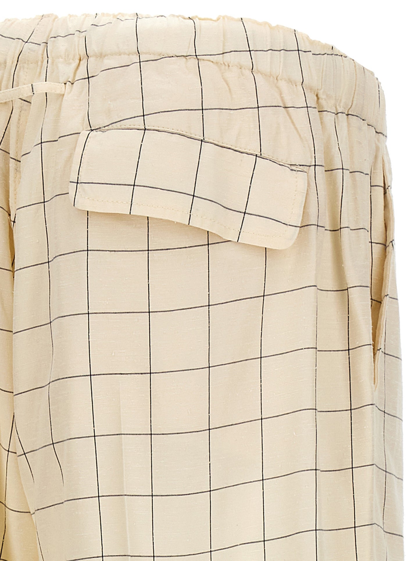 Casual Pants by Undercover for men in rayon silk bicolour, black, white & checkered presents a tailored silhouette, showcasing a tailored and long cut with a refined for a truly tailored aesthetic.