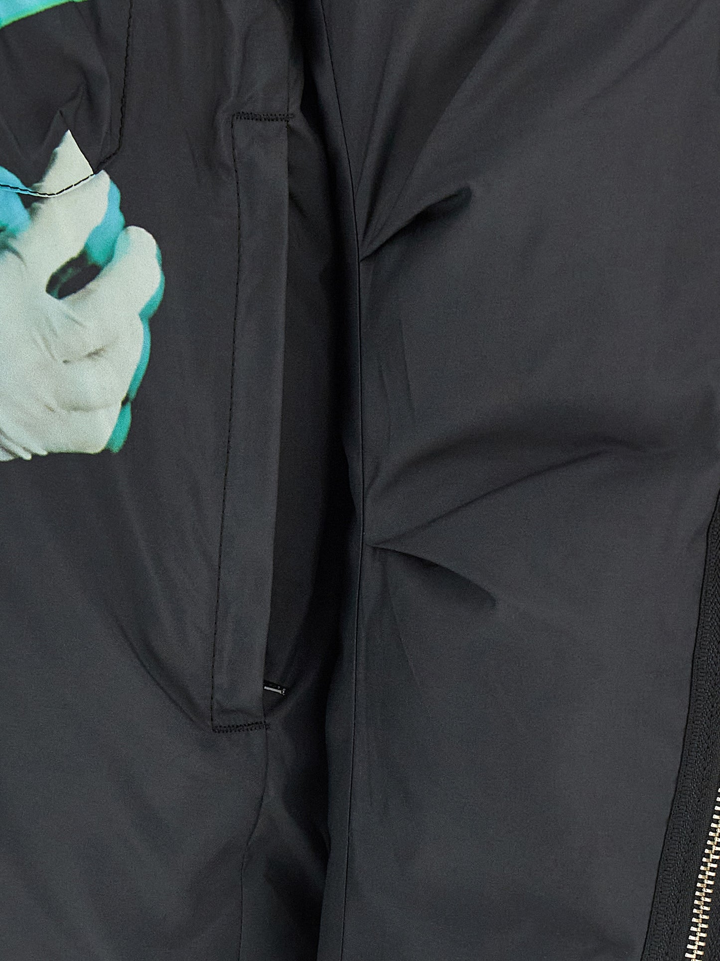 This Puffer Jacket by Undercover for men in nylon & polyester black & print exhibits a edgy silhouette, meticulously detailed with functional insulated & windproof and a edgy for a edgy finish.
