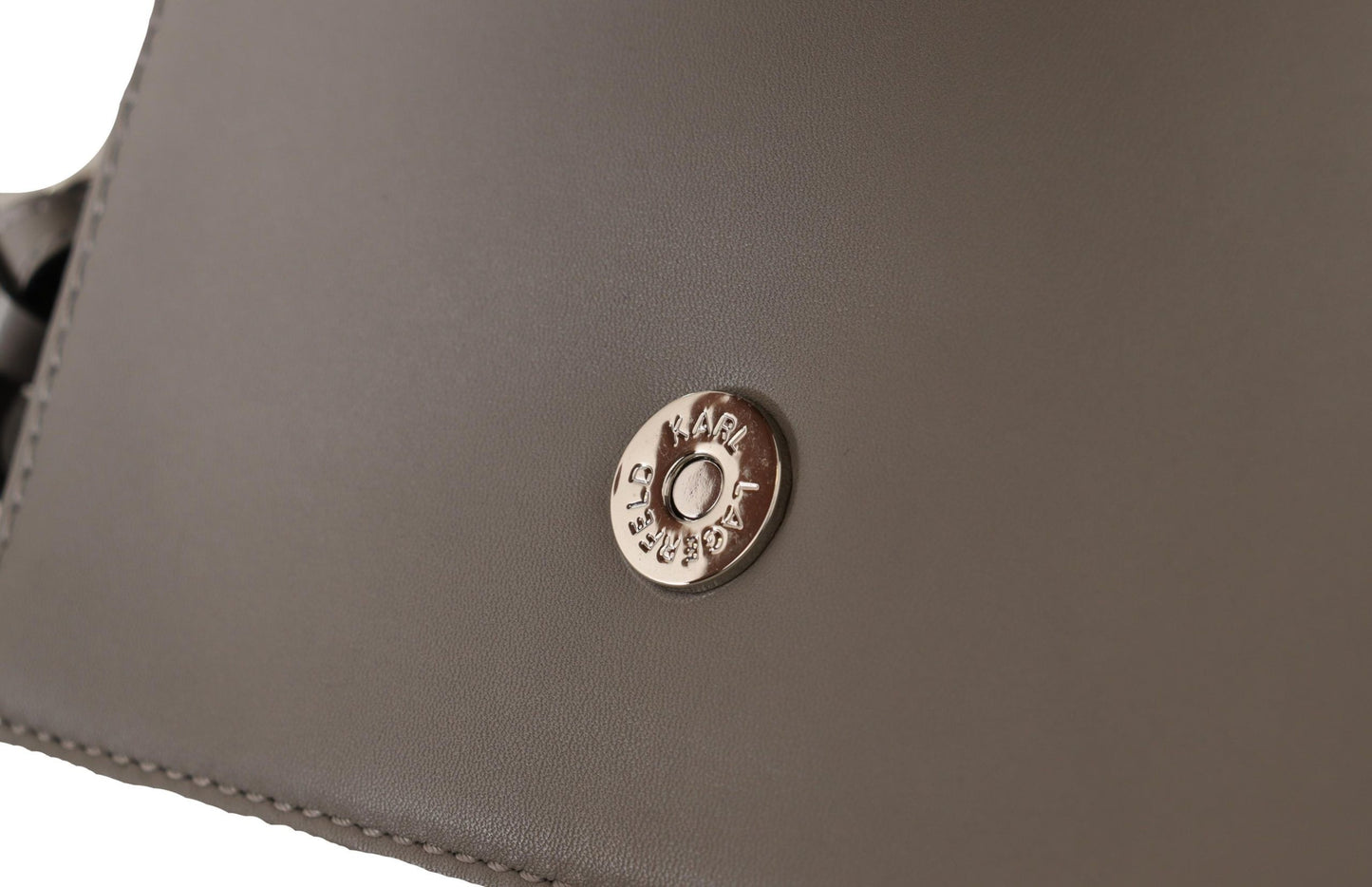 Travel Crossbody Flap Convertible Handbag by Karl Lagerfeld for women in leather gray, light-grey & silver features an exquisite silhouette, showcasing a secure snap, flap & zipper, ample built-in-compartments, and versatile crossbody-strap, shoulder-strap & adjustable-strap for exquisite style.