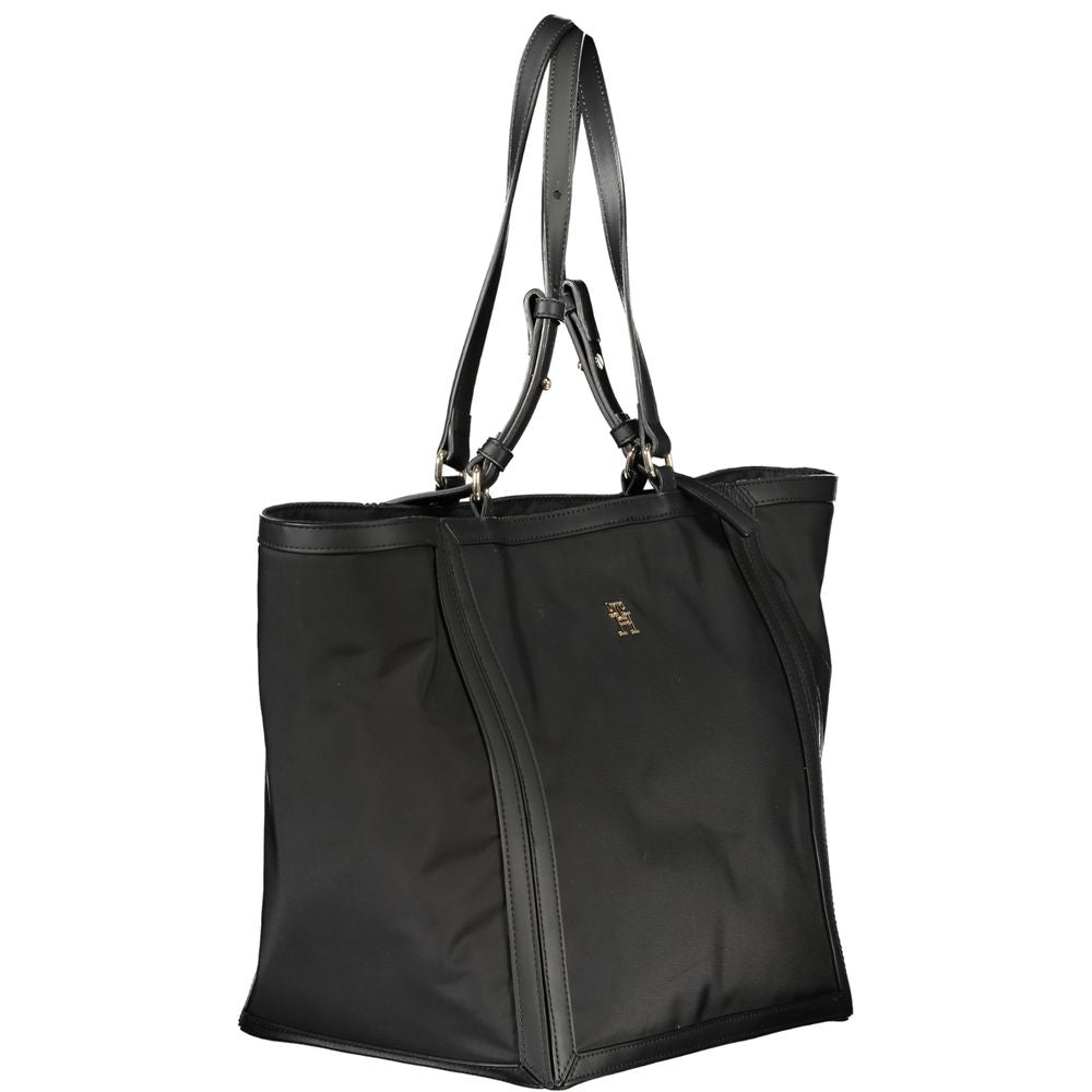 Shopper Tote Convertible Handbag by Tommy Hilfiger for women in polyester black features a polished silhouette with a secure zipper, ample internal-pockets, and polished adjustable-strap & handle for a sophisticated look.