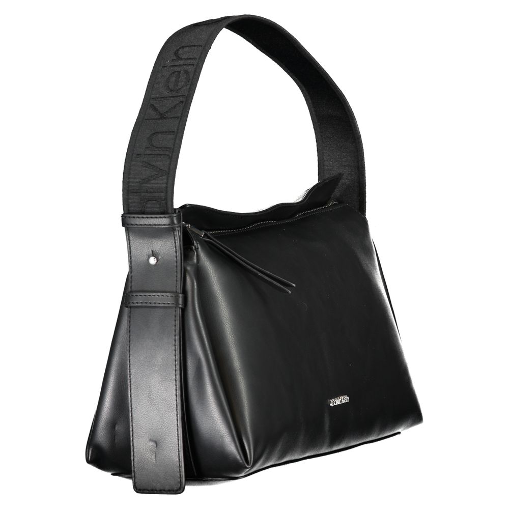 This Shoulder Handbag by Calvin Klein for women in polyester faux leather and black presents a sculptural silhouette featuring a secure zipper, ample document-holder, and versatile shoulder-strap, adjustable-strap & handle for a sculptural finish.
