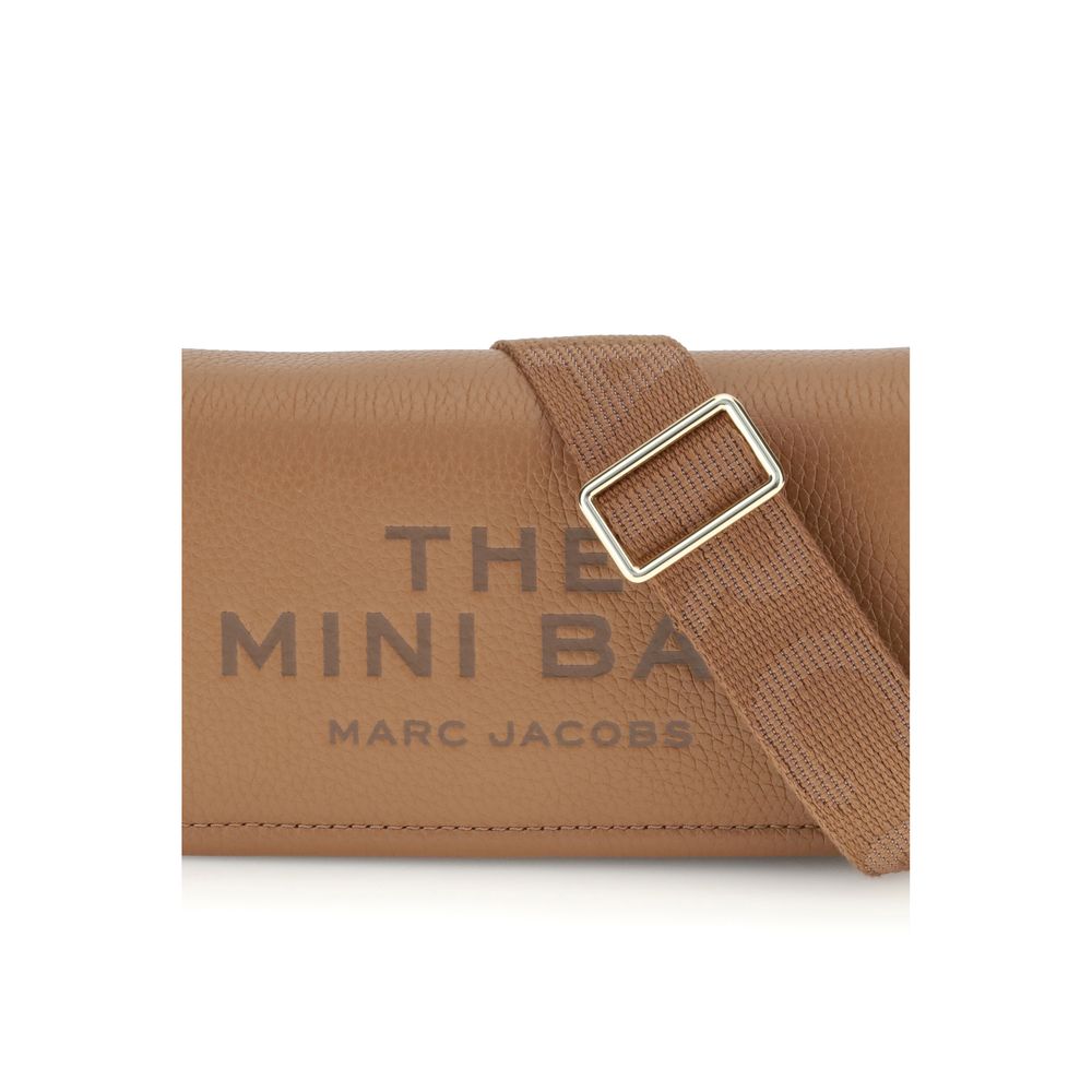 Mini Shoulder Flap Bag by Marc Jacobs for women in bos taurus calf grained leather brown, signature & monogram features a distinguished silhouette, showcasing a secure flap, magnetic & button and distinguished single-compartment with versatile shoulder-strap & adjustable-strap for a distinguished finish.