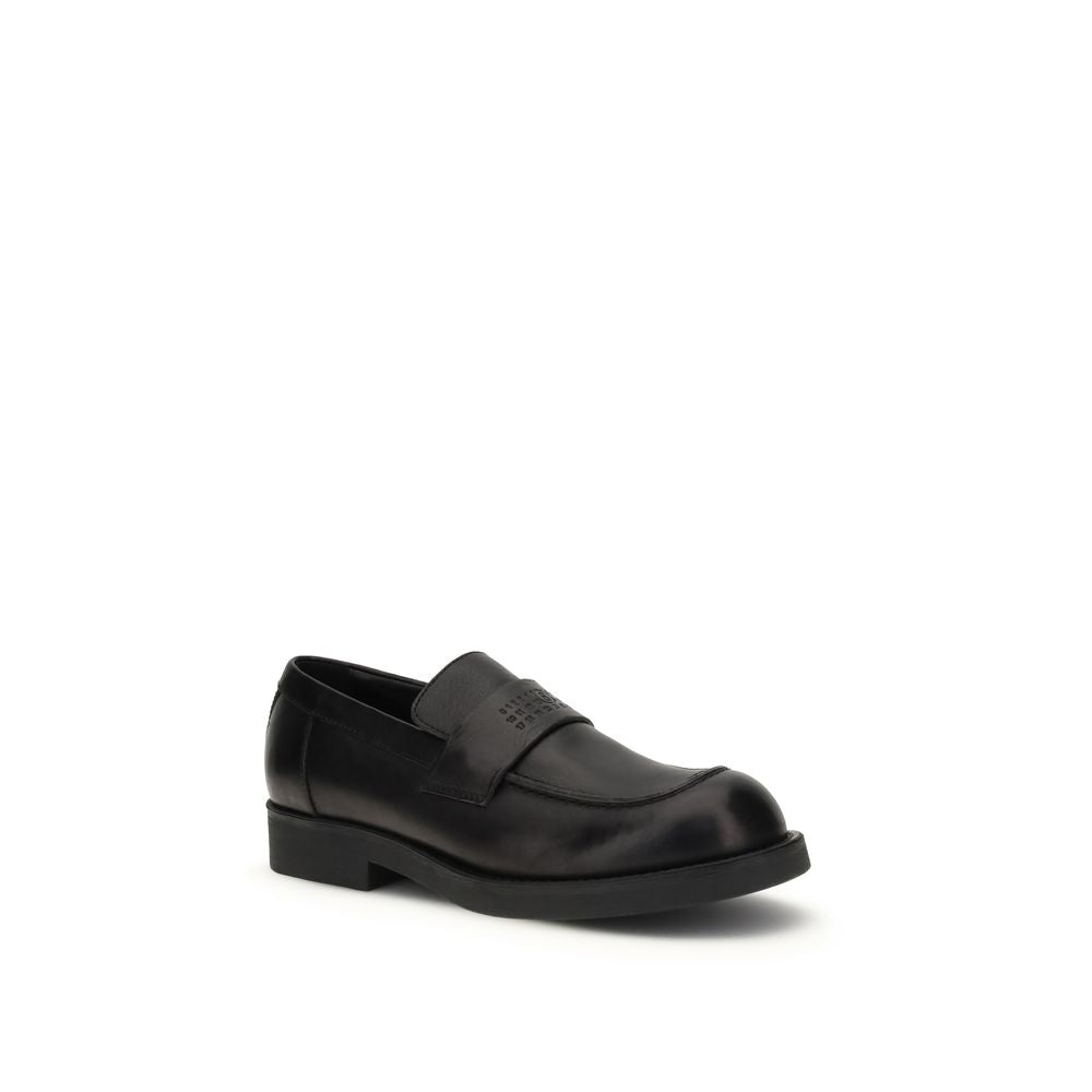 This Flat Loafer Slip-On Shoes by MM6 for men in bos taurus calf leather black features an exquisite silhouette from the Men's Bos Taurus Calf Leather Flat Loafer Slip-On Shoes collection, defined by a sophisticated flat and elegant round toe style.