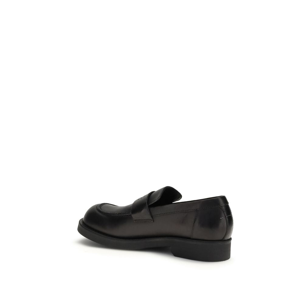 Flat Loafer Slip-On Shoes by MM6 for men in bos taurus calf leather black features an effortless chic silhouette, showcasing the Men's Bos Taurus Calf Leather Flat Loafer Slip-On Shoes design with an effortless chic flat and a round toe style for a effortless chic look.