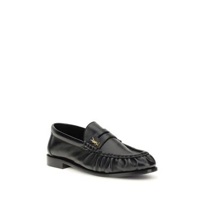 Flat Loafer Slip-On Shoes by Saint Laurent for women in leather & metal black, gold & signature features an dynamic silhouette from the Cassandre Women's Leather & Metal Flat Loafer Slip-On Shoes collection, defined by a dynamic moc toe style and flat for a dynamic look.