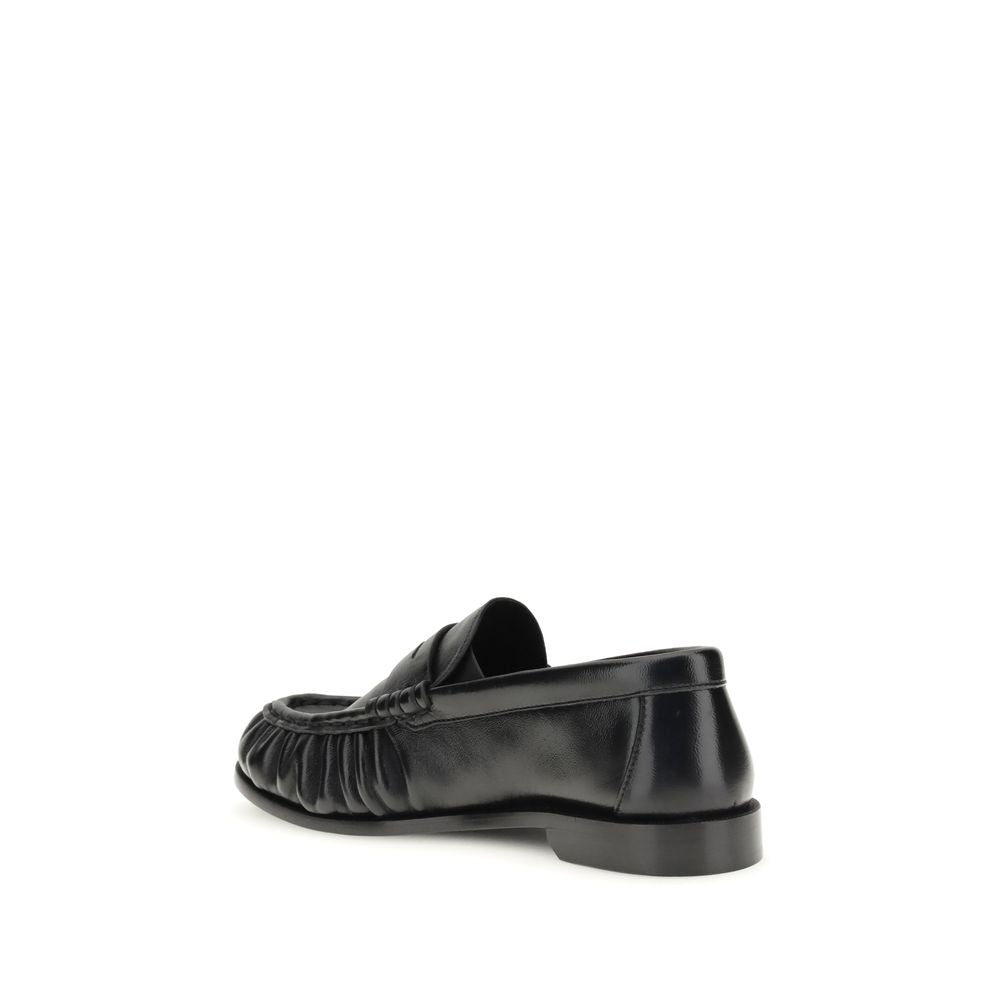 Flat Loafer Slip-On Shoes by Saint Laurent for women in leather & metal black, gold & signature features an effortless chic silhouette, showcasing the Cassandre Women's Leather & Metal Flat Loafer Slip-On Shoes design with an effortless chic flat and a moc toe style for a effortless chic look.