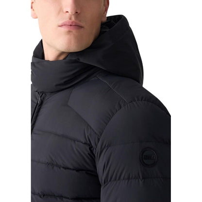 Hooded Overcoat by Colmar Originals for men in stretch polyamide black showcases a enveloping silhouette, detailed with distinctive pockets, hooded & insulated and a enveloping hooded neckline.
