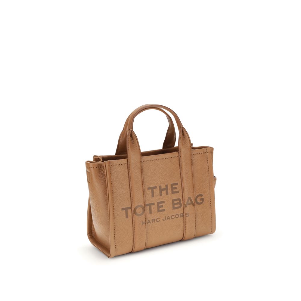 This Small Crossbody Tote Handbag by Marc Jacobs for women in bos taurus calf grained leather and brown, monogram & print presents a sculptural silhouette featuring a secure , ample , and versatile crossbody-strap, shoulder-strap, handle & adjustable-strap for a sculptural finish.