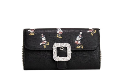 This Small Crossbody Clutch Handbag by Kate Spade for women in faux patent leather and black & silver presents a sculptural silhouette featuring a secure snap & zipper, ample cardholder, and versatile crossbody-strap & detachable-strap for a sculptural finish.