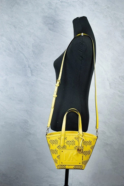 This Small Crossbody Messenger Pouch Handbag by Michael Kors for women in faux leather and gold & yellow presents a sculptural silhouette featuring a secure zipper, ample removable-pouch, and versatile crossbody-strap, adjustable-strap, detachable-strap & handle for a sculptural finish.