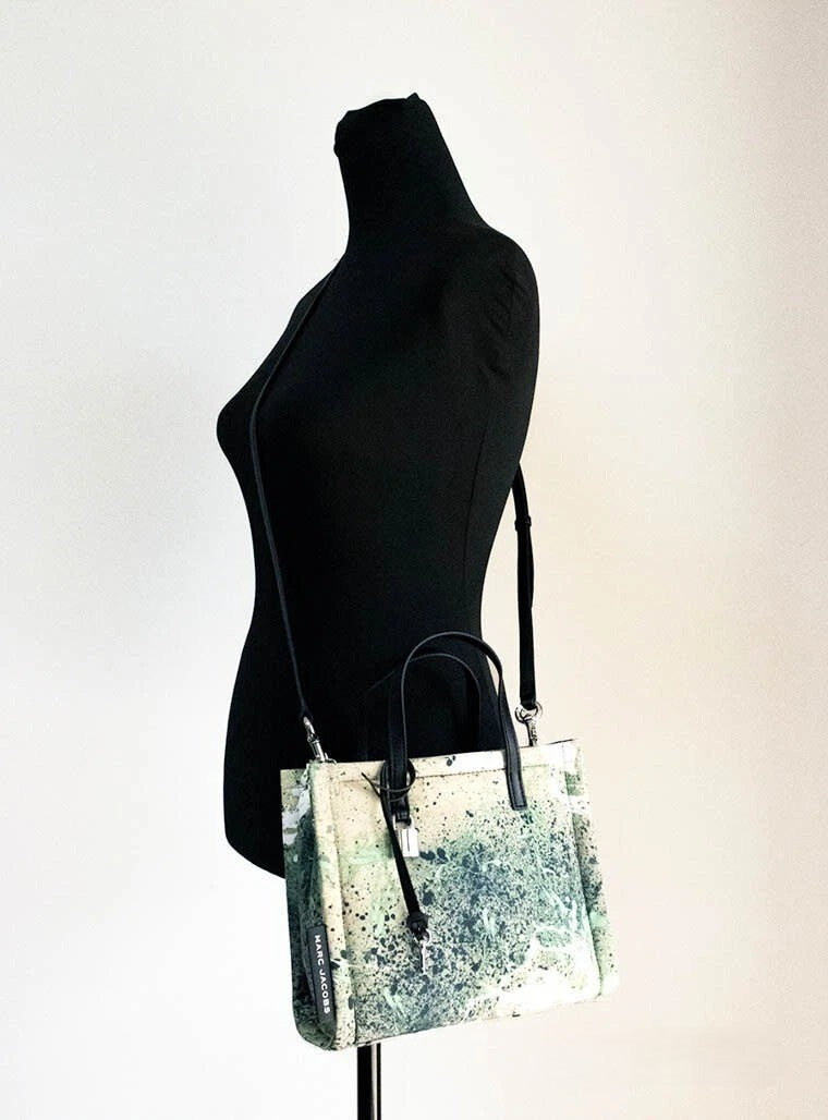 Mini Crossbody Travel Tote Handbag by Marc Jacobs for women in raffia & leather green, multicolor, silver & print features an versatile silhouette, showcasing a secure zipper and versatile with versatile crossbody-strap, adjustable-strap, detachable-strap & handle for a versatile finish.