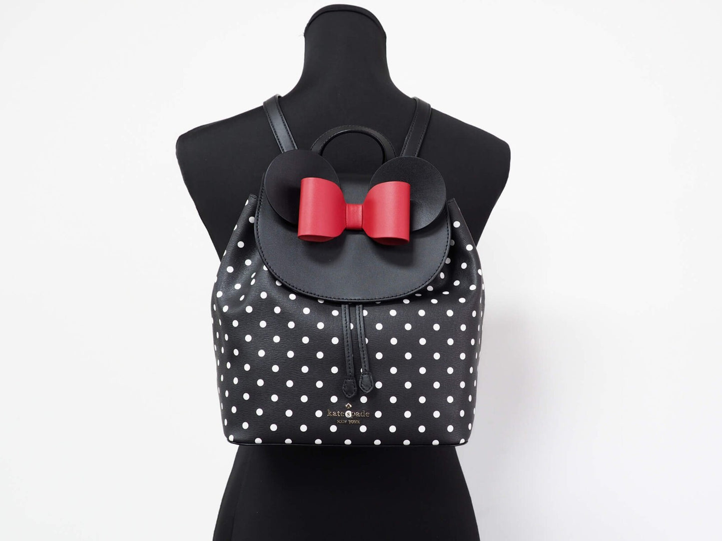 Medium Drawstring Backpack by Kate Spade for women in leather black, gold, silver & patterned showcases a stately Disney Minnie Mouse X Leather Medium Drawstring Backpack design, featuring a secure snap, flap, drawstring & magnetic with stately and versatile crossbody-strap & backpack-strap.