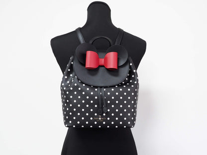 Medium Drawstring Backpack by Kate Spade for women in leather black, gold, silver & patterned showcases a stately Disney Minnie Mouse X Leather Medium Drawstring Backpack design, featuring a secure snap, flap, drawstring & magnetic with stately and versatile crossbody-strap & backpack-strap.