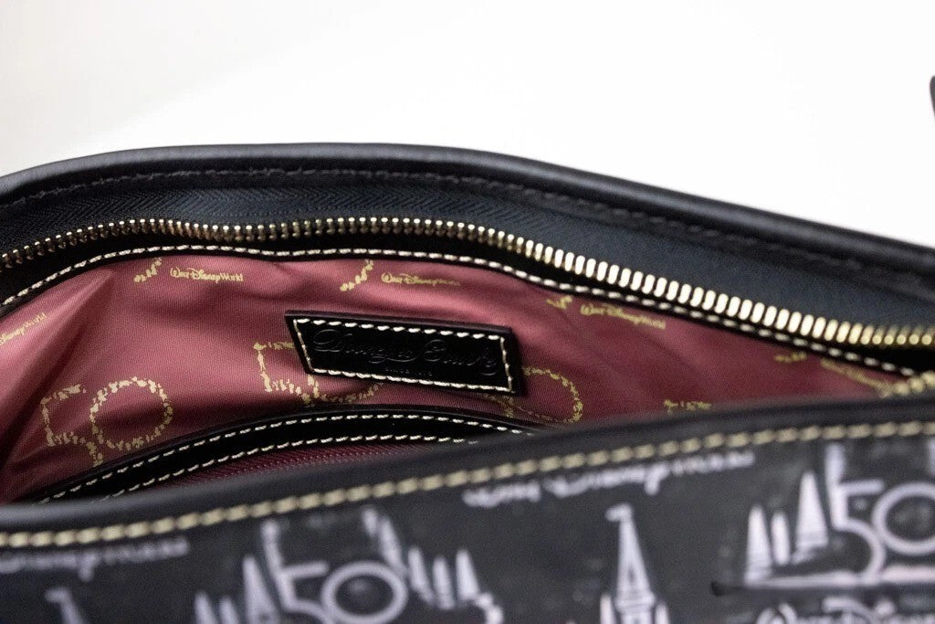 Medium Crossbody Travel Tote Bag by Dooney & Bourke for women in leather black, gold & patterned features a jet-set Walt Disney World 50Th Anniversary Leather Medium Crossbody Travel Tote Bag design, complete with a secure zipper, ample , and versatile crossbody-strap, adjustable-strap, detachable-strap & handle for a jet-set look.