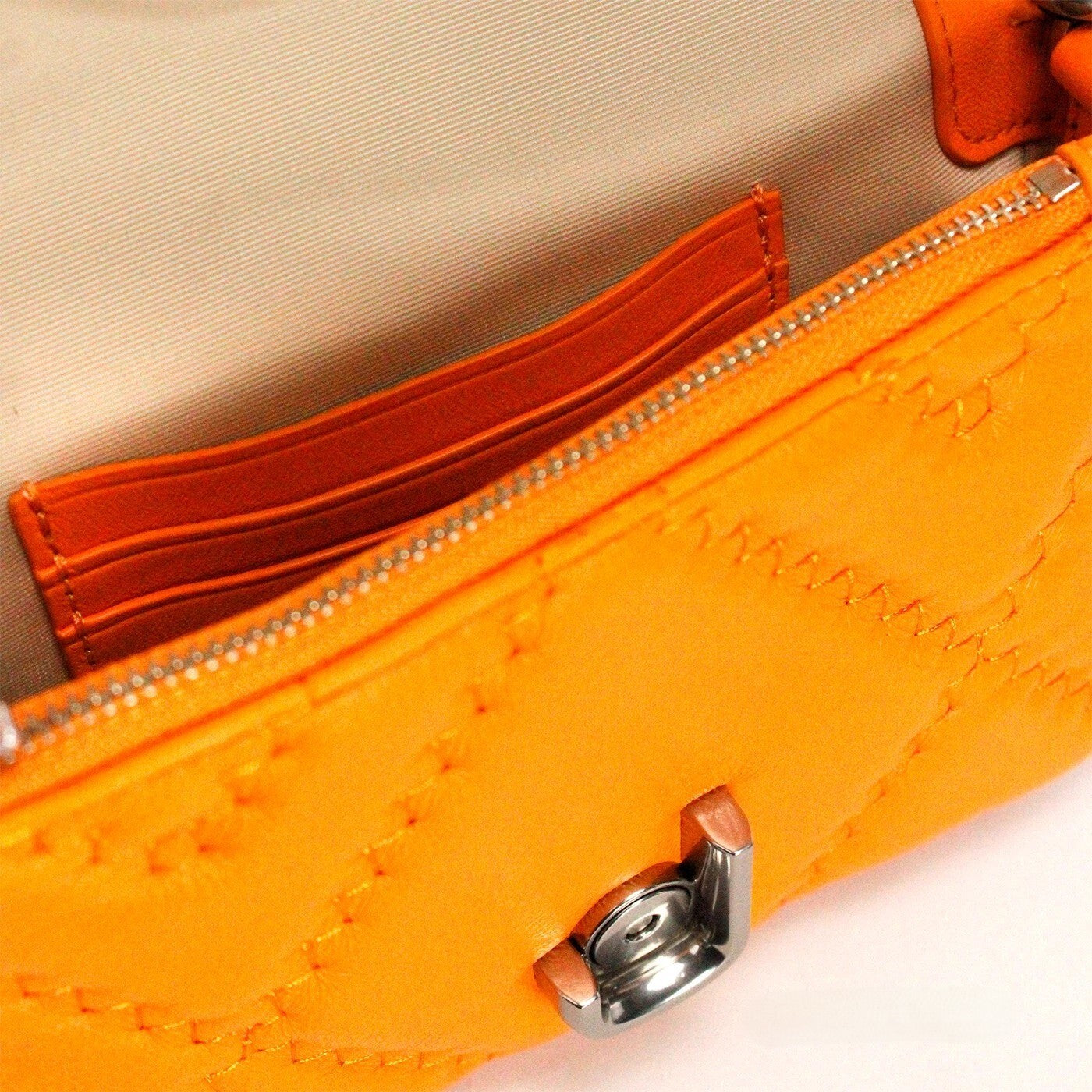 Mini Quilted 2-in-1 Shoulder & Crossbody Evening Bag by Marc Jacobs for women in leather orange & silver presents a statuesque silhouette, showcasing a secure zipper & magnetic and statuesque cardholder with versatile crossbody-strap, shoulder-strap, adjustable-strap & detachable-strap for a sophisticated look.