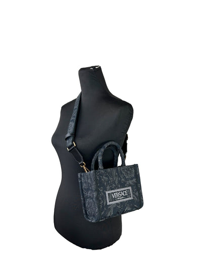 Small Travel Shopper Tote Handbag by Versace for women in calf & python leather black, gold & jacquard features a refined silhouette, showcasing a secure , organized , and versatile shoulder-strap, handle, adjustable-strap & detachable-strap for a refined finish.