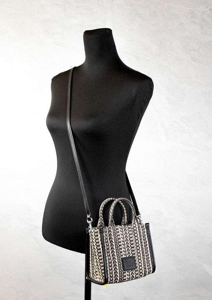 Mini Crossbody Travel Tote Handbag by Marc Jacobs for women in calfskin leather & nylon beige, silver, patterned, jacquard & monogram features a transformative elegance silhouette, showcasing a secure zipper, organized cardholder, and versatile crossbody-strap, adjustable-strap, detachable-strap & handle for a transformative elegance look.