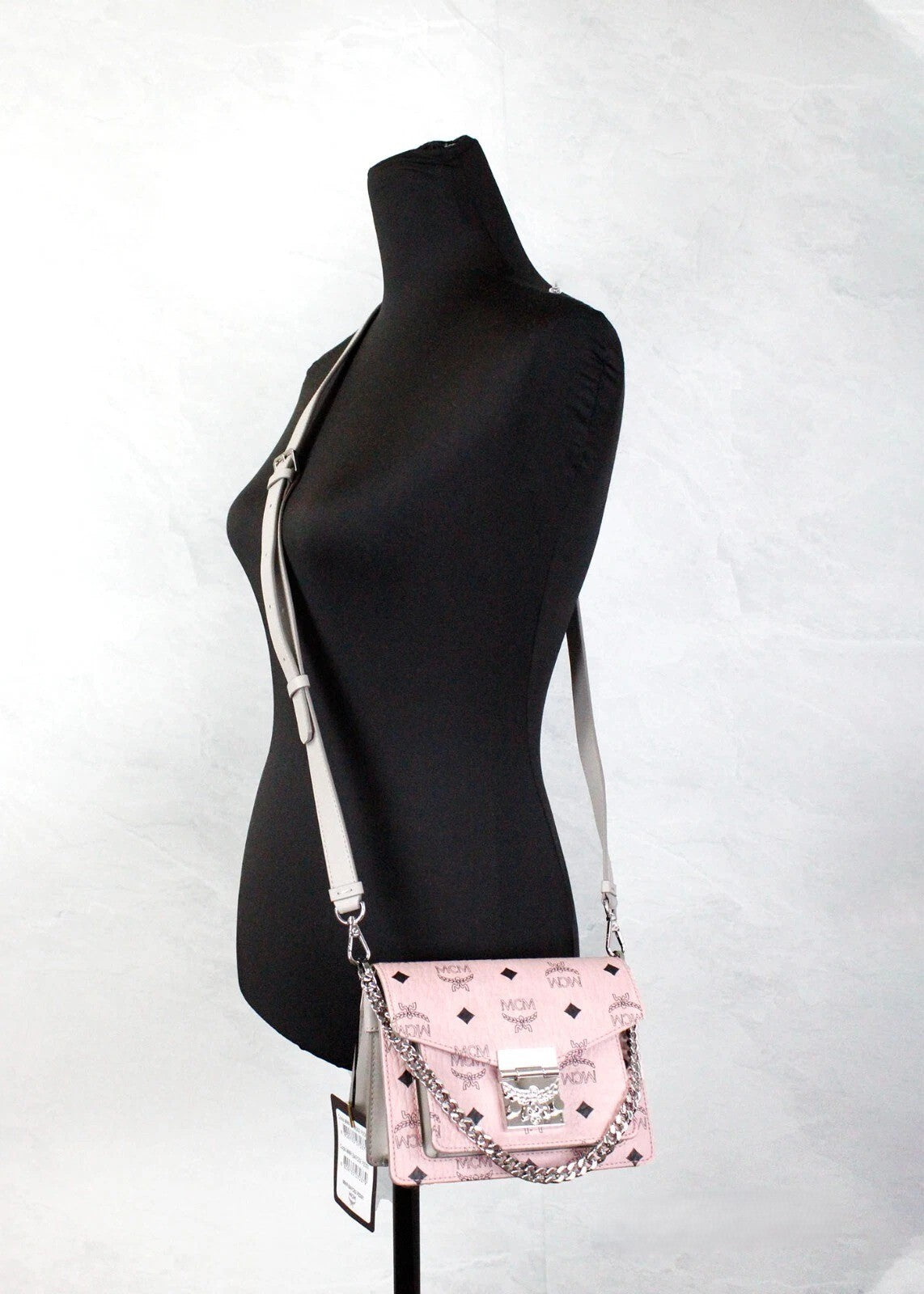 Mini Crossbody Flap Handbag by MCM for women in faux patent leather pink, silver, patterned & signature features an multi-faceted design with a secure flap & push-lock, ample , and versatile crossbody-strap, adjustable-strap & detachable-strap for a multi-faceted finish.