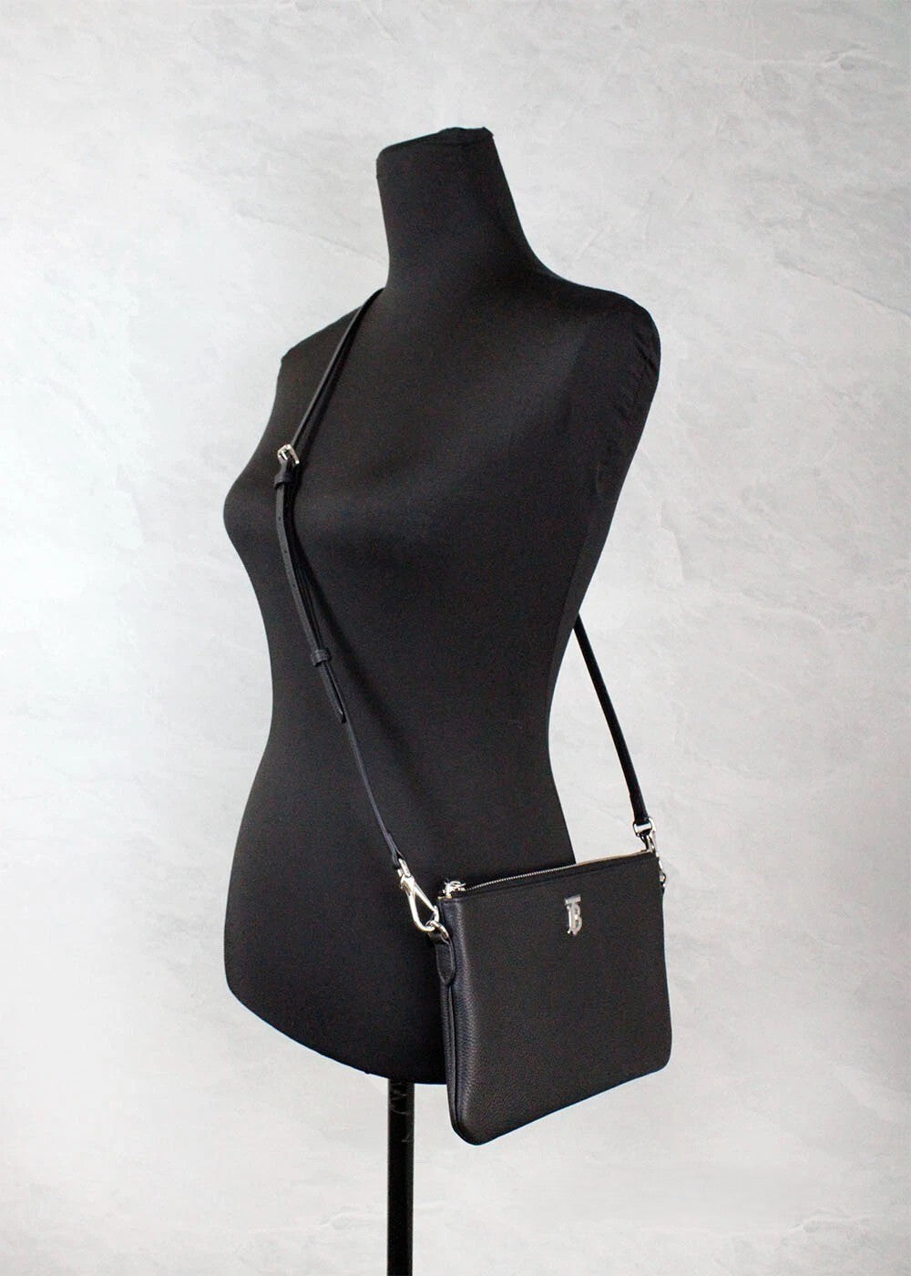 Small Crossbody Pouch Handbag by Burberry for women in leather black, silver & monogram features a versatile chic silhouette, meticulously detailed with a secure zipper, ample cardholder, and versatile crossbody-strap, adjustable-strap & detachable-strap.