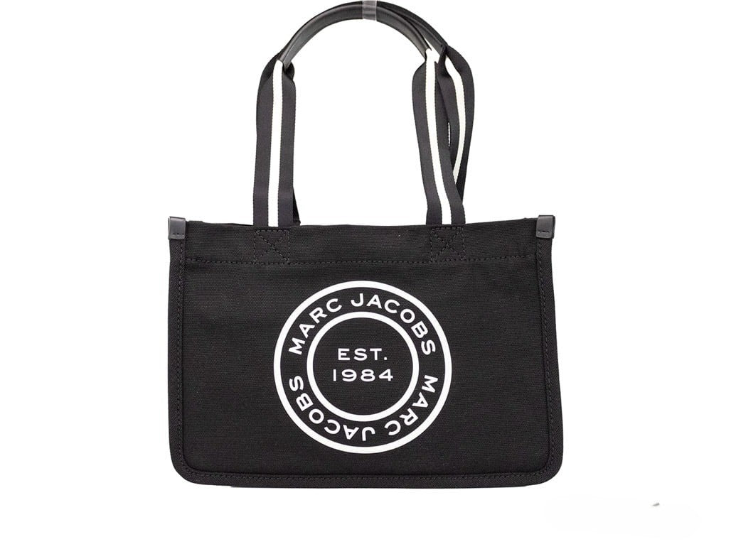 Medium Travel Tote Shoulder Bag by Marc Jacobs for women in canvas black & silver presents a statuesque silhouette, showcasing a secure zipper and statuesque with versatile handle for a sophisticated look.
