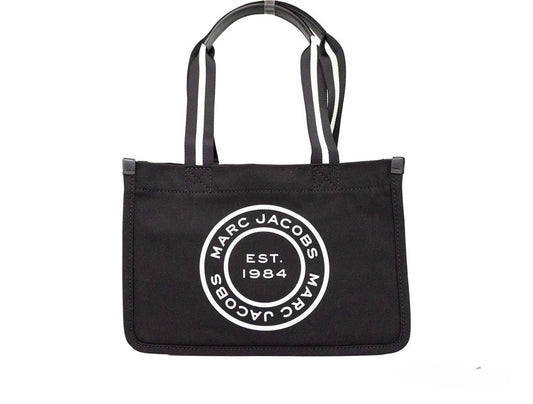 Medium Travel Tote Shoulder Bag by Marc Jacobs for women in canvas black & silver presents a statuesque silhouette, showcasing a secure zipper and statuesque with versatile handle for a sophisticated look.