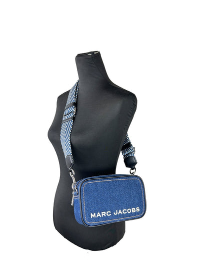 Crossbody Camera Handbag by Marc Jacobs for women in denim silver features a transformative elegance silhouette, showcasing a secure zipper, organized cardholder, and versatile crossbody-strap, adjustable-strap & detachable-strap for a transformative elegance look.