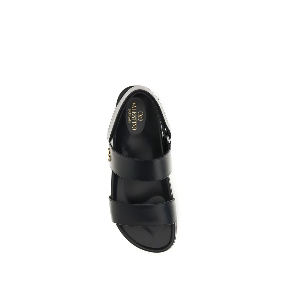 Flat Sandals by Valentino Garavani for men in bos taurus calfskin leather black, gold & signature presents a sculptural silhouette, showcasing the V Logo Men's Bos Taurus Calfskin Leather Flat Sandals design with a sculptural flat and for a premium look.
