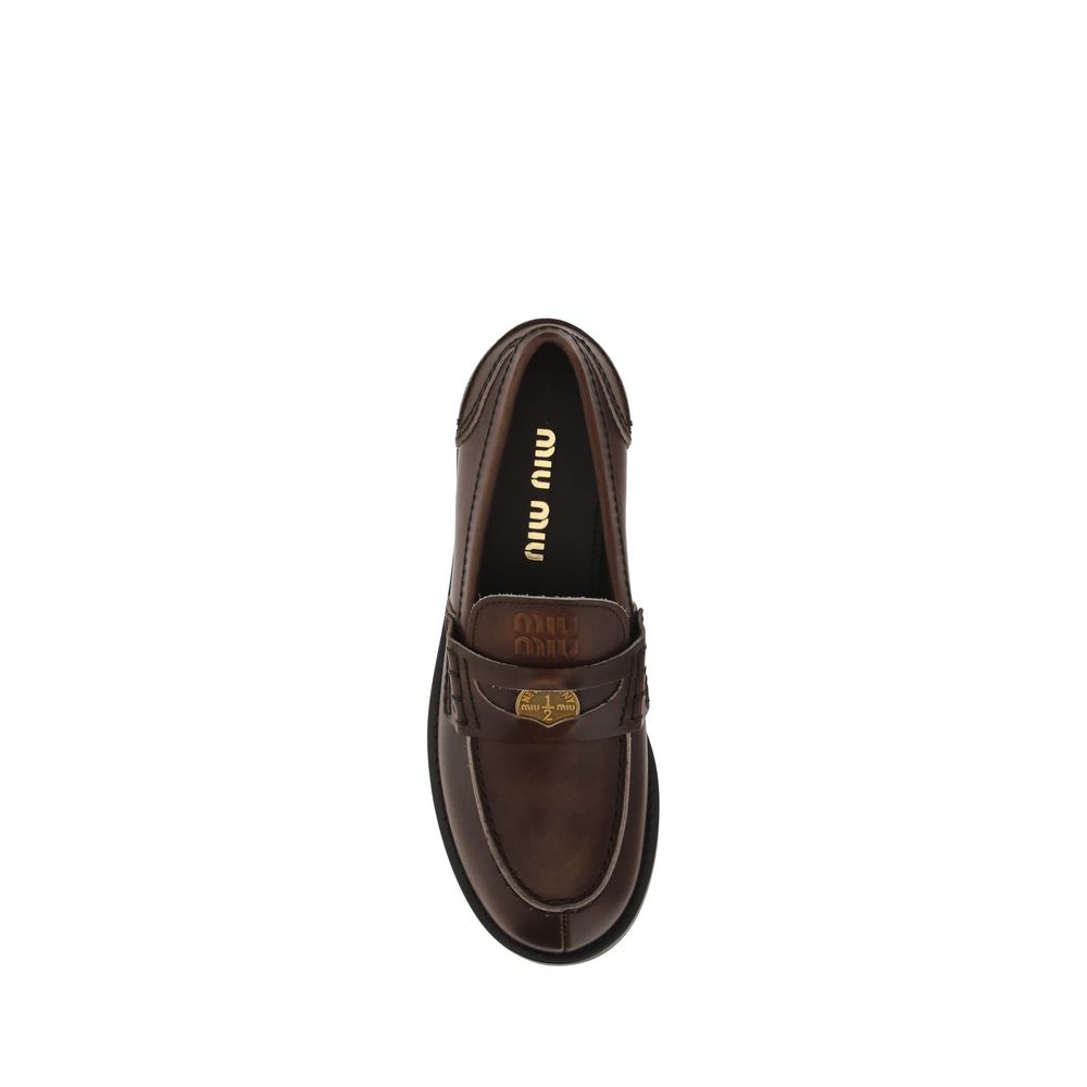 Loafer Slip-On Shoes by Miu Miu for women in bos taurus calf leather brown & signature showcases a impeccable silhouette as Women's Bos Taurus Calf Leather Loafer Slip-On Shoes, artfully designed with a impeccable block-heel and refined for a impeccable finish.