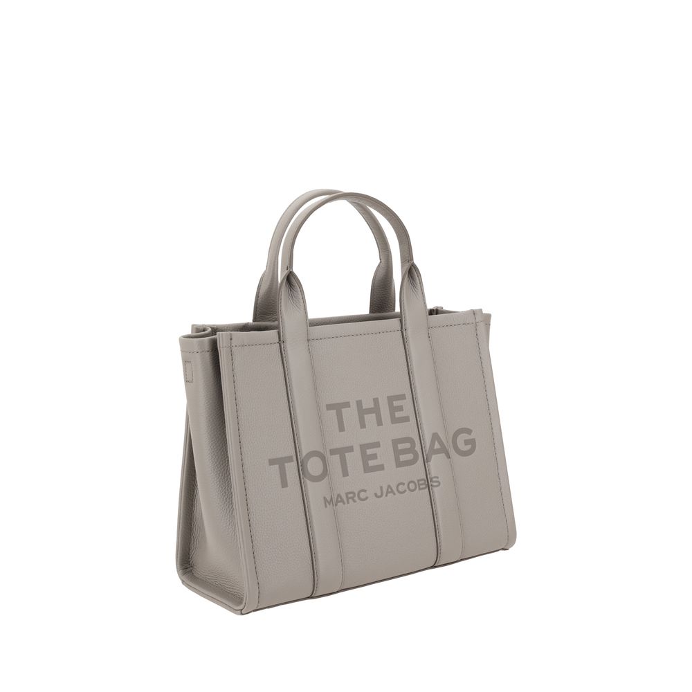 Medium Tote Handbag by Marc Jacobs for women in bos taurus calf grained leather gray & monogram features a signature silhouette, showcasing a secure zipper and signature with versatile shoulder-strap, handle & adjustable-strap for a sophisticated look.