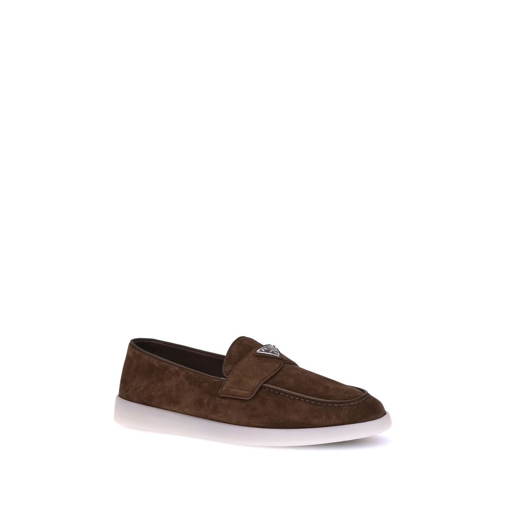 Flat Loafer Slip-On Shoes by Prada for men in bos taurus calf suede leather brown showcases a impeccable silhouette as Men's Bos Taurus Calf Suede Leather Flat Loafer Slip-On Shoes, artfully designed with a impeccable flat and refined almond toe style for a impeccable finish.