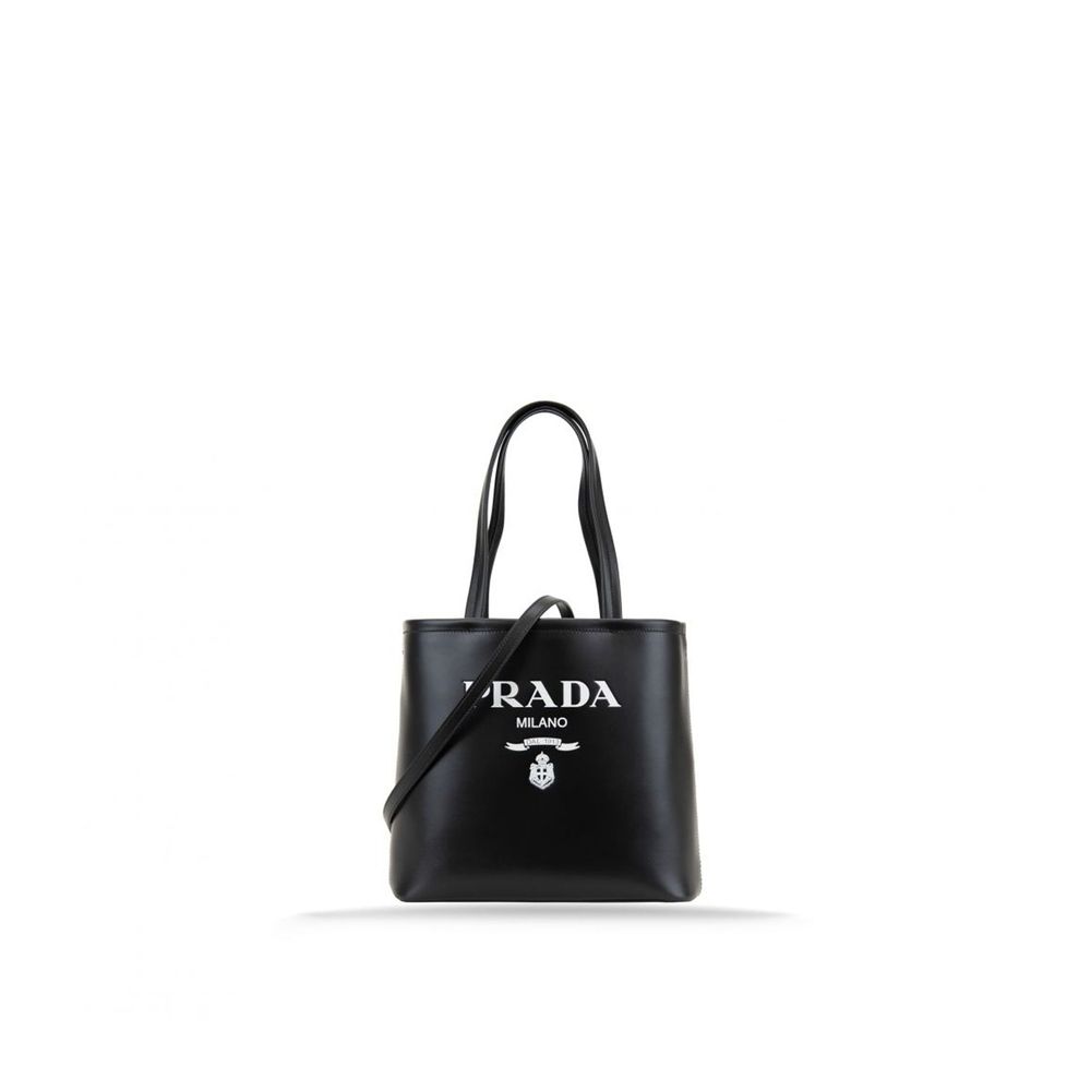 Tote Bag by Prada for women in calfskin leather black & print showcases a statuesque Calfskin Leather Tote Bag design, featuring a secure , ample , and versatile shoulder-strap, handle & detachable-strap for a statuesque finish.