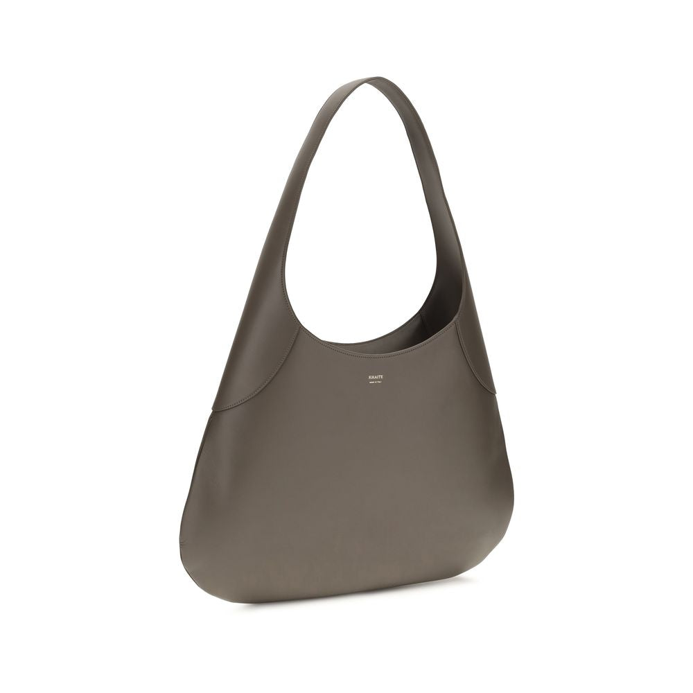 This Large Shoulder Hobo Handbag by Khaite for women in bos taurus calfskin leather and gray & gold presents a sculptural silhouette featuring a secure , ample , and versatile shoulder-strap for a sculptural finish.