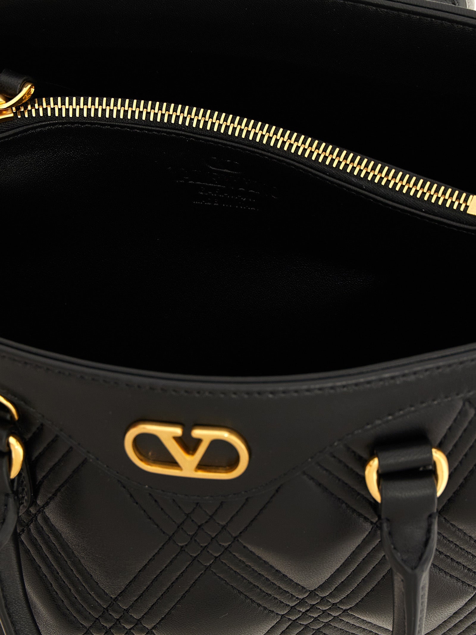 Quilted Handbag by Valentino Garavani for women in lamb leather black & signature features a ornamental silhouette, showcasing a secure , ample , and ornamental shoulder-strap, adjustable-strap & handle for a sophisticated look.