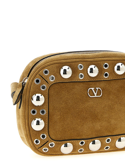 Crossbody Messenger Handbag by Valentino Garavani for unisex in suede leather beige & signature features a multifaceted silhouette, showcasing a secure zipper and multifaceted with versatile crossbody-strap, shoulder-strap & adjustable-strap for multifaceted style.