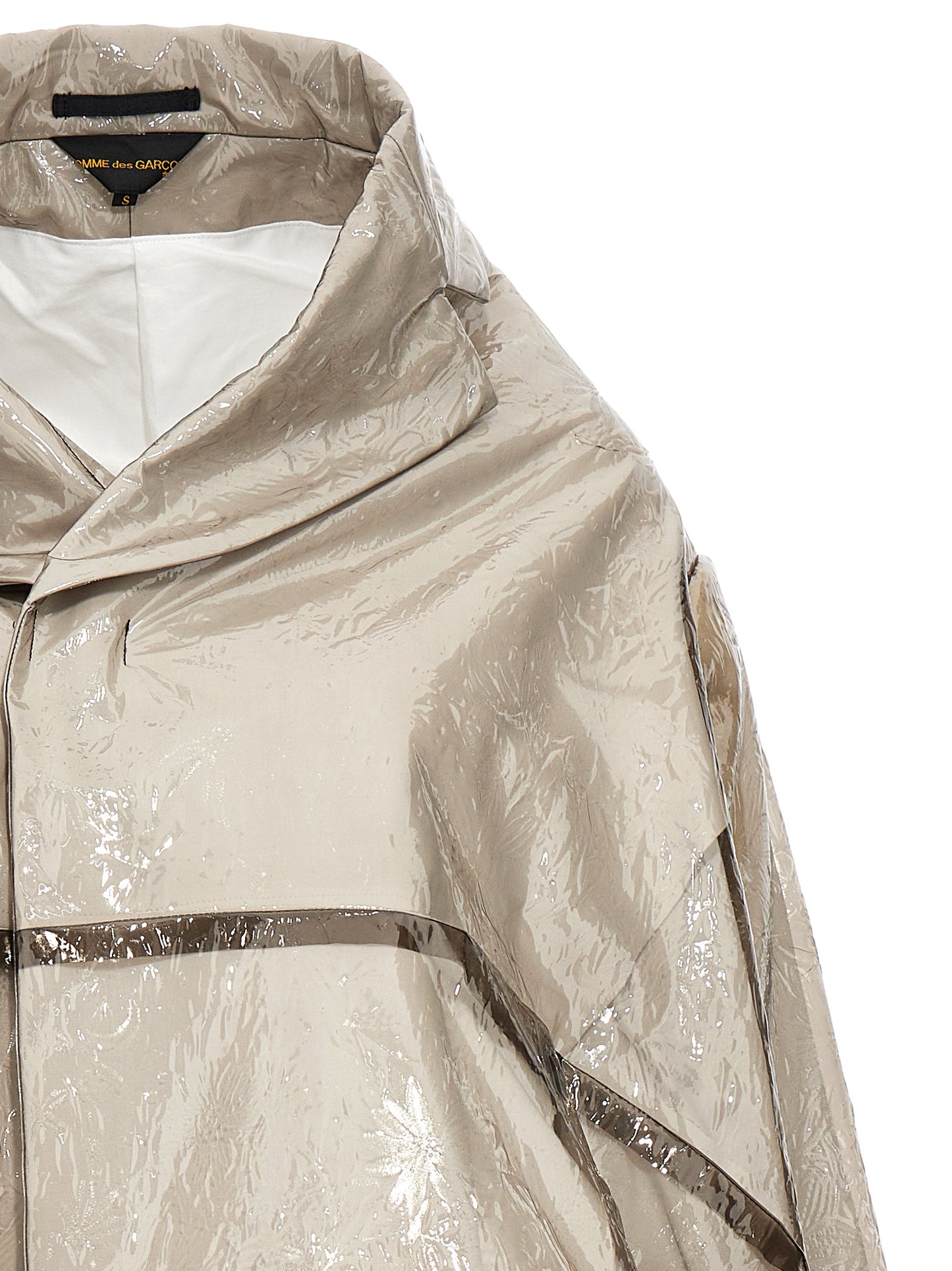 Trench Coat by Comme Des Garçons for women in polyethylene & polyurethane gray presents an sculptural silhouette, artfully detailed with a sculptural and functional pockets for a truly sculptural finish.