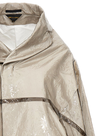Trench Coat by Comme Des Garçons for women in polyethylene & polyurethane gray presents an sculptural silhouette, artfully detailed with a sculptural and functional pockets for a truly sculptural finish.