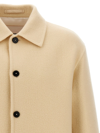 Overcoat by Jil Sander for men in virgin wool beige showcases a architectural silhouette, artfully detailed with a distinctive and functional pockets for a architectural finish.