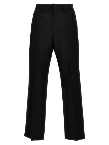 Trousers by Valentino Garavani for men in virgin wool black features a sculptural silhouette, showcasing a sculptural and long with a sophisticated for a sculptural finish.