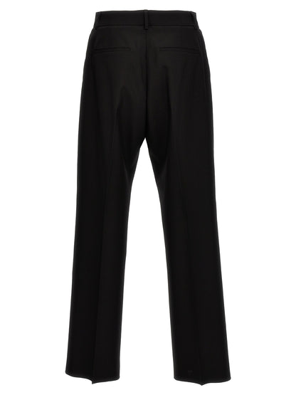 Trousers by Valentino Garavani for men in virgin wool black features a artisanal silhouette, showcasing a sophisticated with a long and for a artisanal finish.