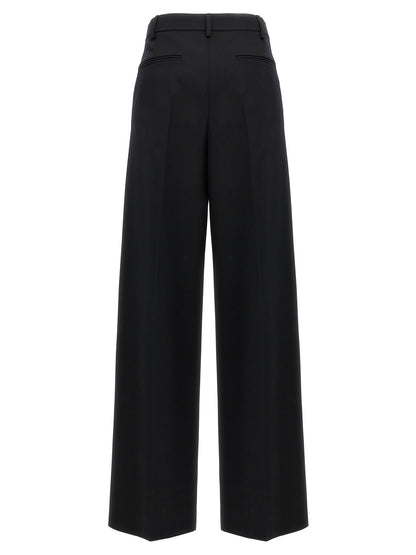 Trousers by Valentino Garavani for women in virgin wool black presents a perennial silhouette, meticulously tailored with a straight-leg & wide cut, long finish, and an elegant .