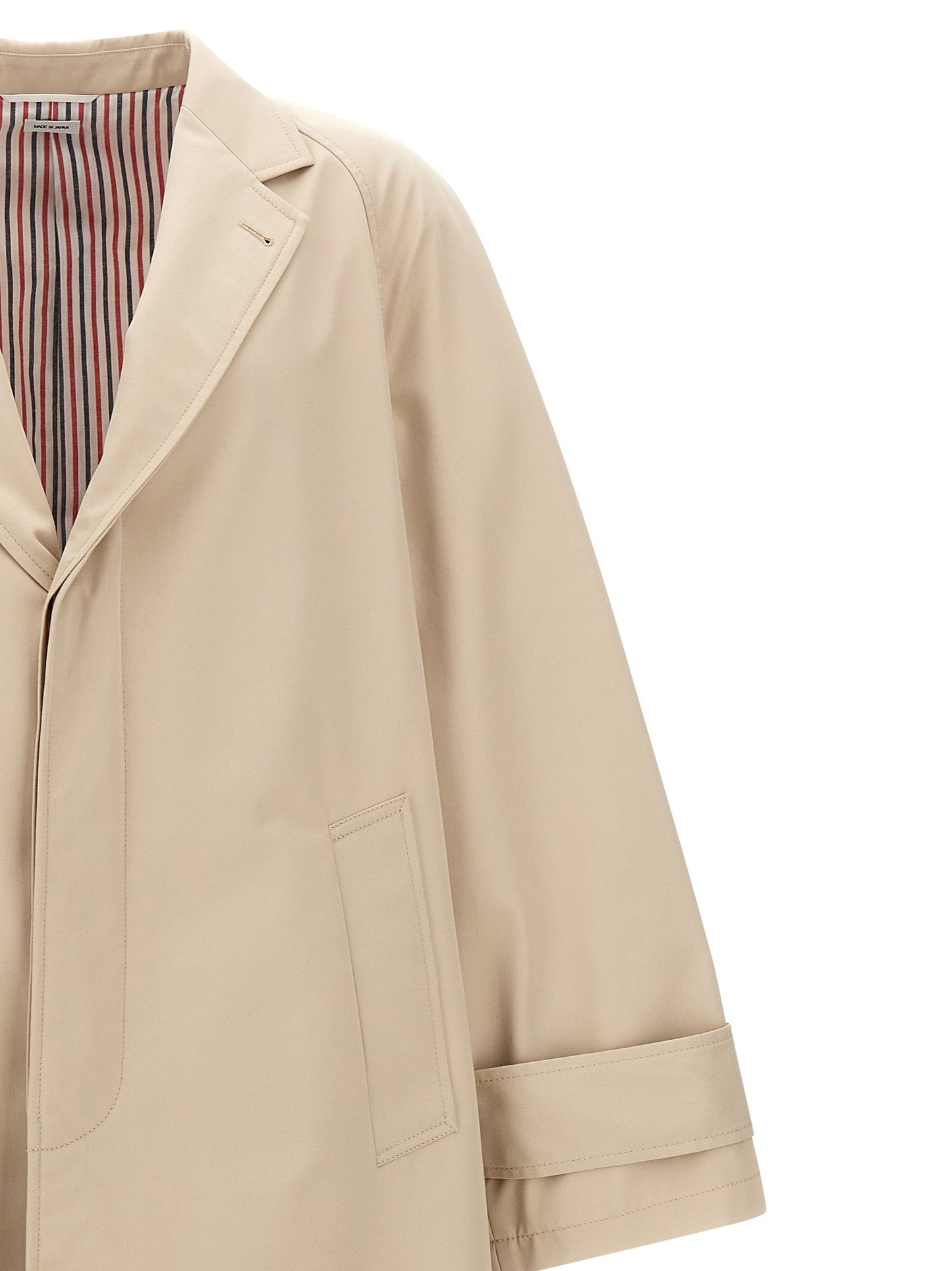 Trench Coat by Thom Browne for men in polyester polyurethane cotton beige presents a distinguished silhouette, artfully detailed with pockets and a distinguished for a sophisticated, distinguished finish.