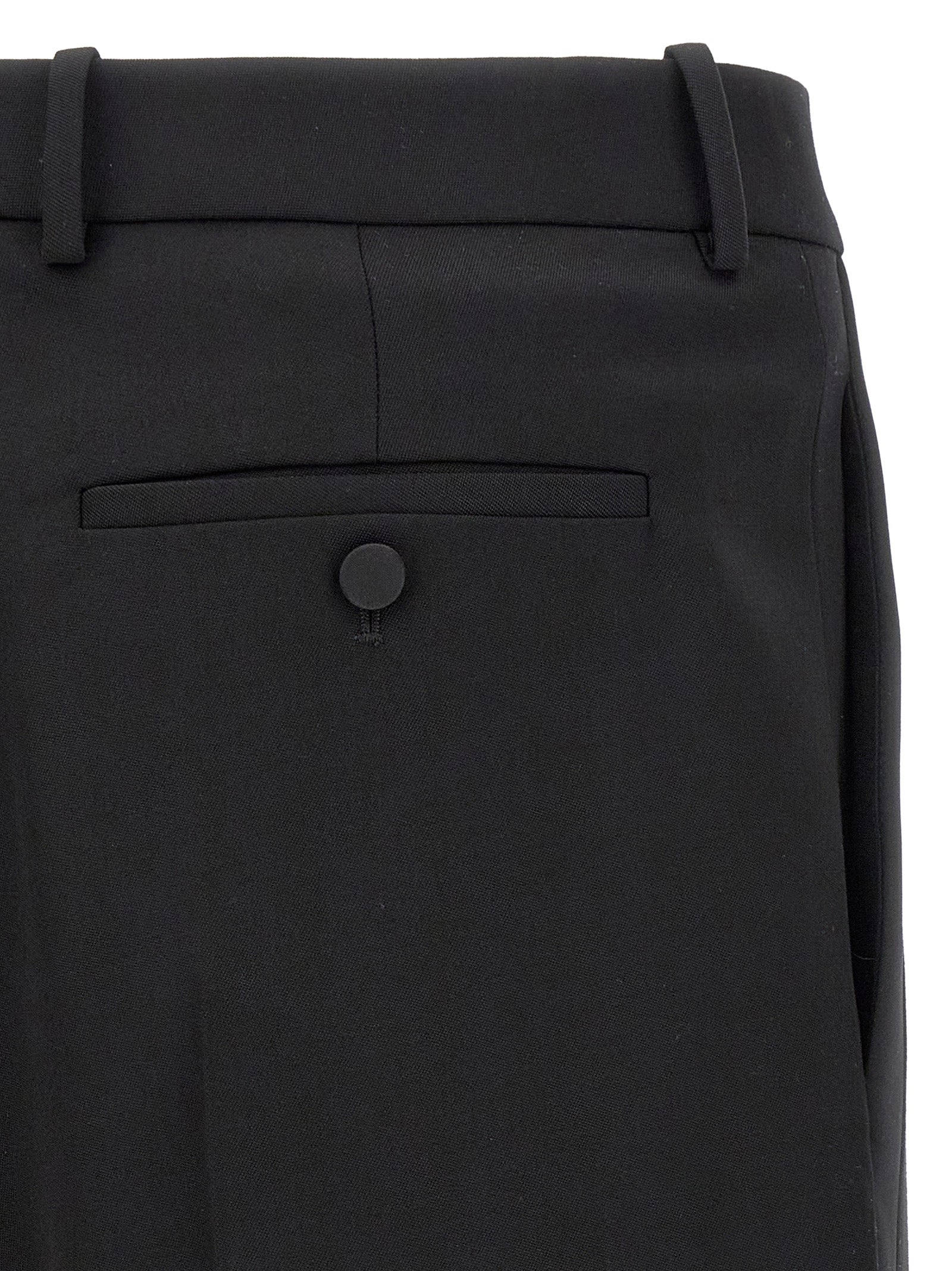 Trousers by Saint Laurent for men in satin wool black features a sculptural silhouette, showcasing a sculptural and long with a sophisticated high rise for a sculptural finish.