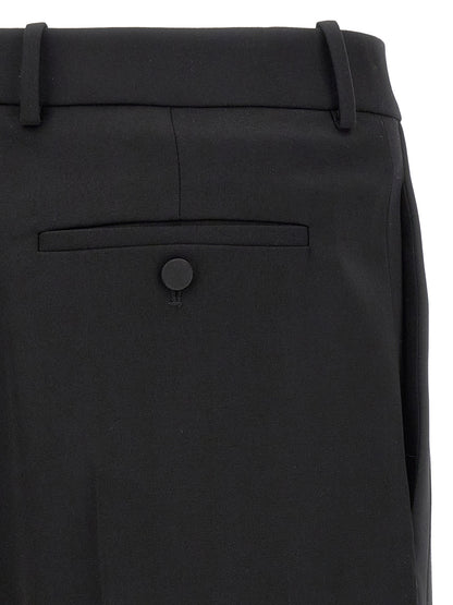 Trousers by Saint Laurent for men in satin wool black features a sculptural silhouette, showcasing a sculptural and long with a sophisticated high rise for a sculptural finish.