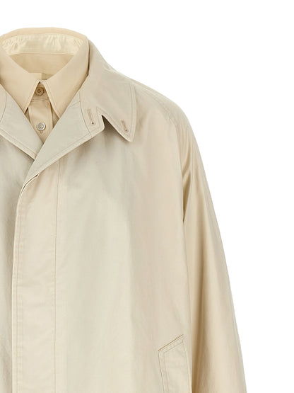 Trench Coat by Maison Margiela for men in cotton beige presents a distinguished silhouette, artfully detailed with pockets and a distinguished split neckline for a sophisticated, distinguished finish.
