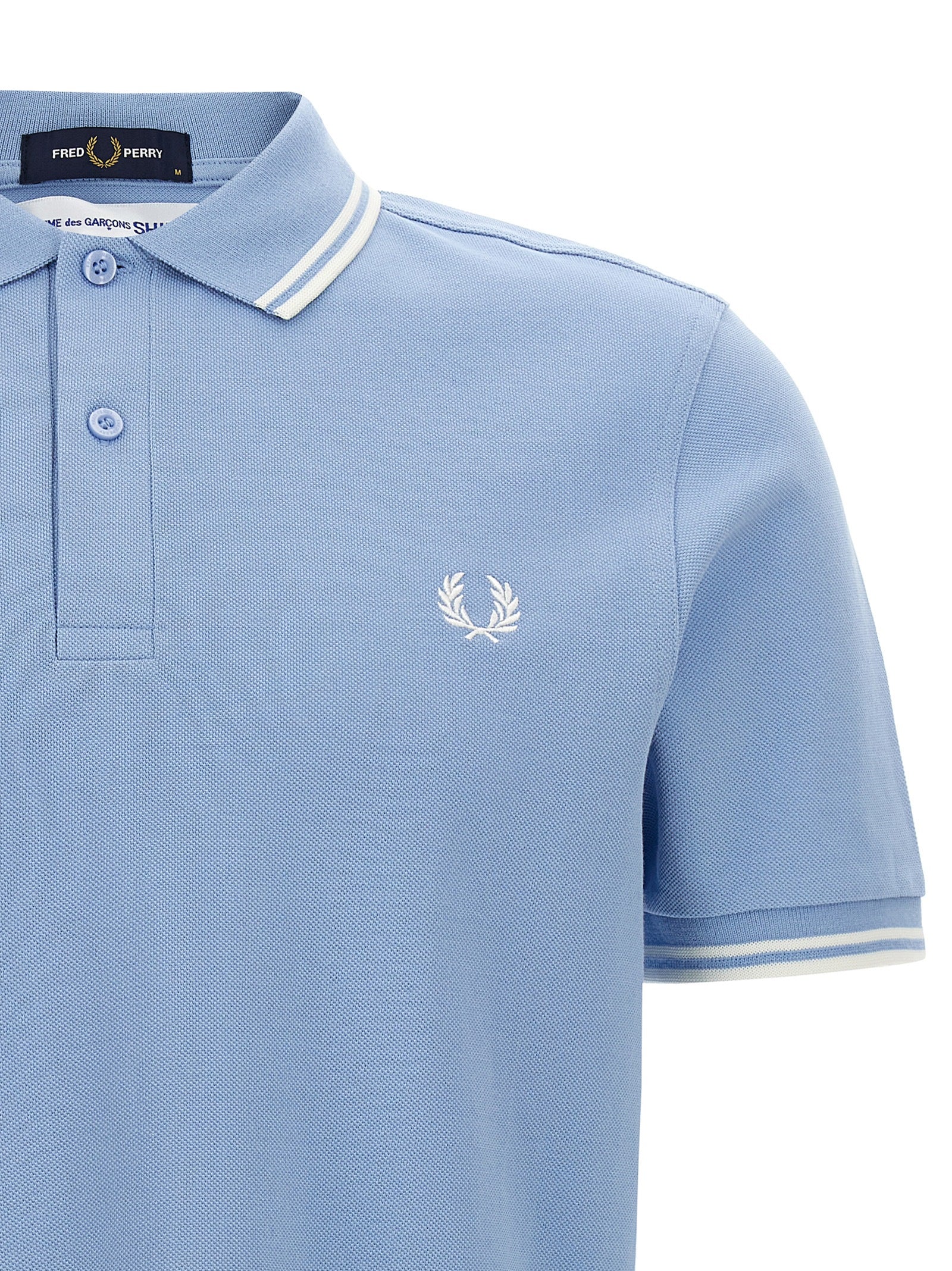 This Polo Shirt by Comme Des Garçons for men in cotton light-blue & print presents a flawless silhouette, showcasing flawless detailing and a refined for a truly flawless aesthetic.