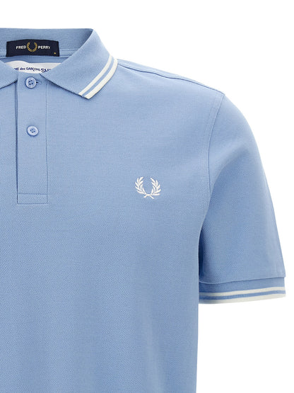 This Polo Shirt by Comme Des Garçons for men in cotton light-blue & print presents a flawless silhouette, showcasing flawless detailing and a refined for a truly flawless aesthetic.